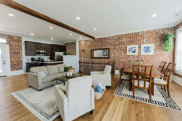 Exposed-brick open living and dining room in the Arch View from Private Deck apartment, downtown St. Louis